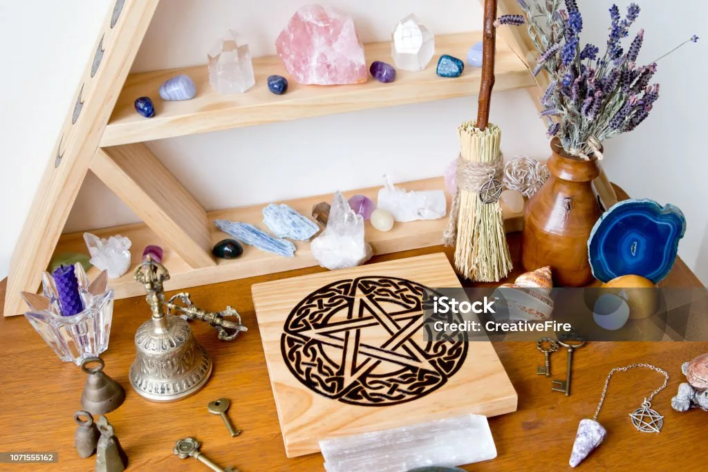 Pagan witchcraft altar with pentacle, crystals, candles, and herbs for ritual setup. Position: After "What Is Witchcraft" section. External Source Link: Britannica on Witchcraft History